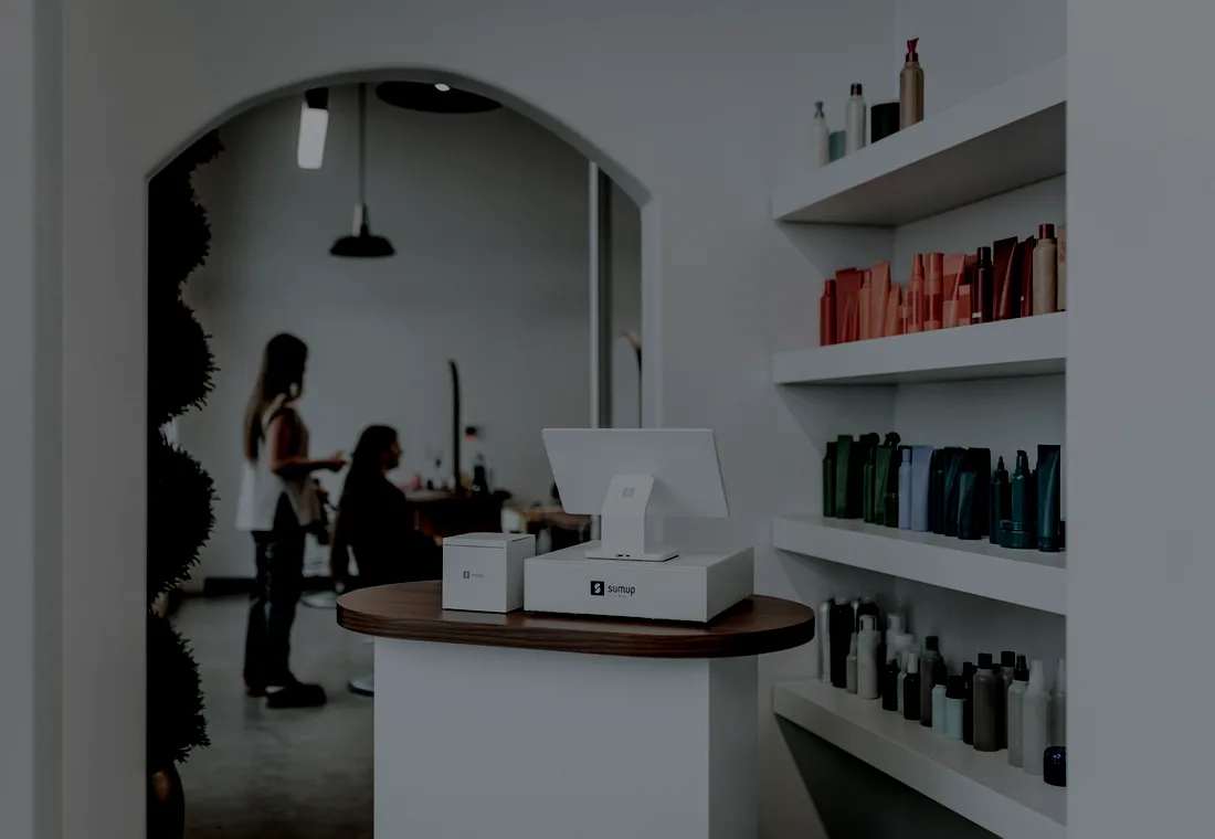Recepção do salão com clientes sendo atendidas no balcão